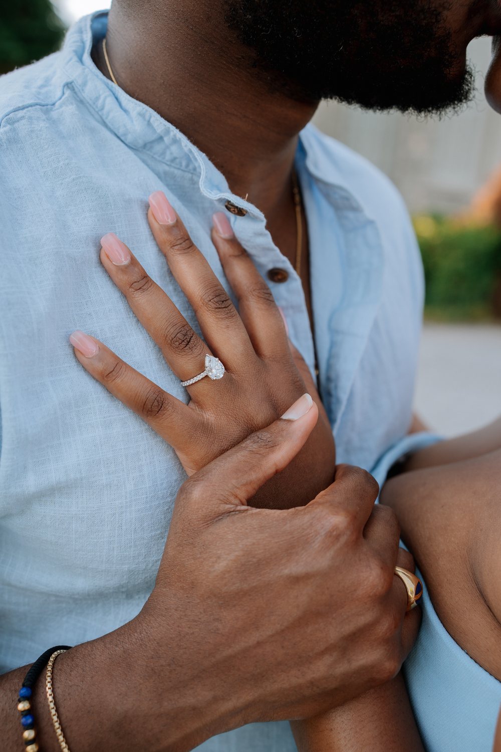 Sally's engagement ring, her hand resting on Adetunji's chest